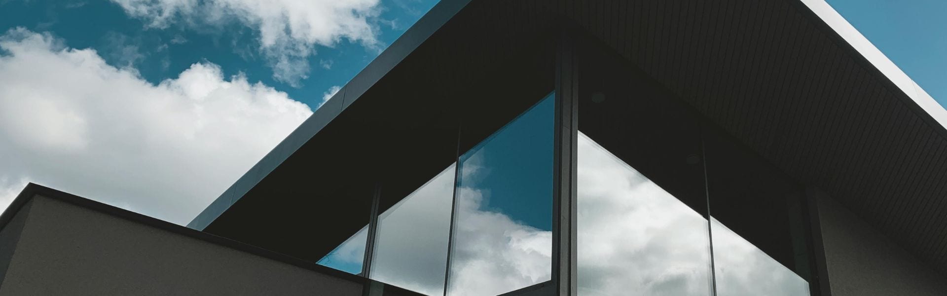 Modern commercial building with large glass windows reflecting the sky