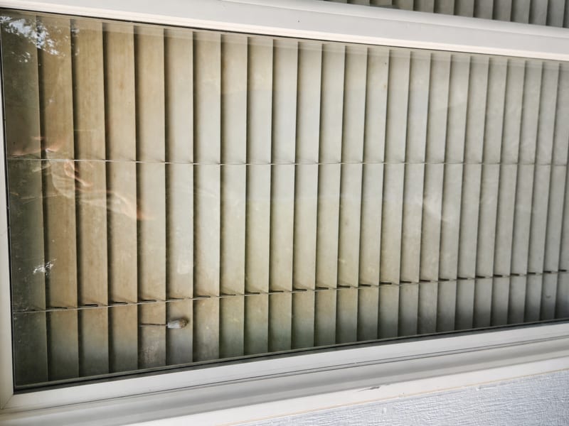 Window clouded with hard water mineral stains before restoration